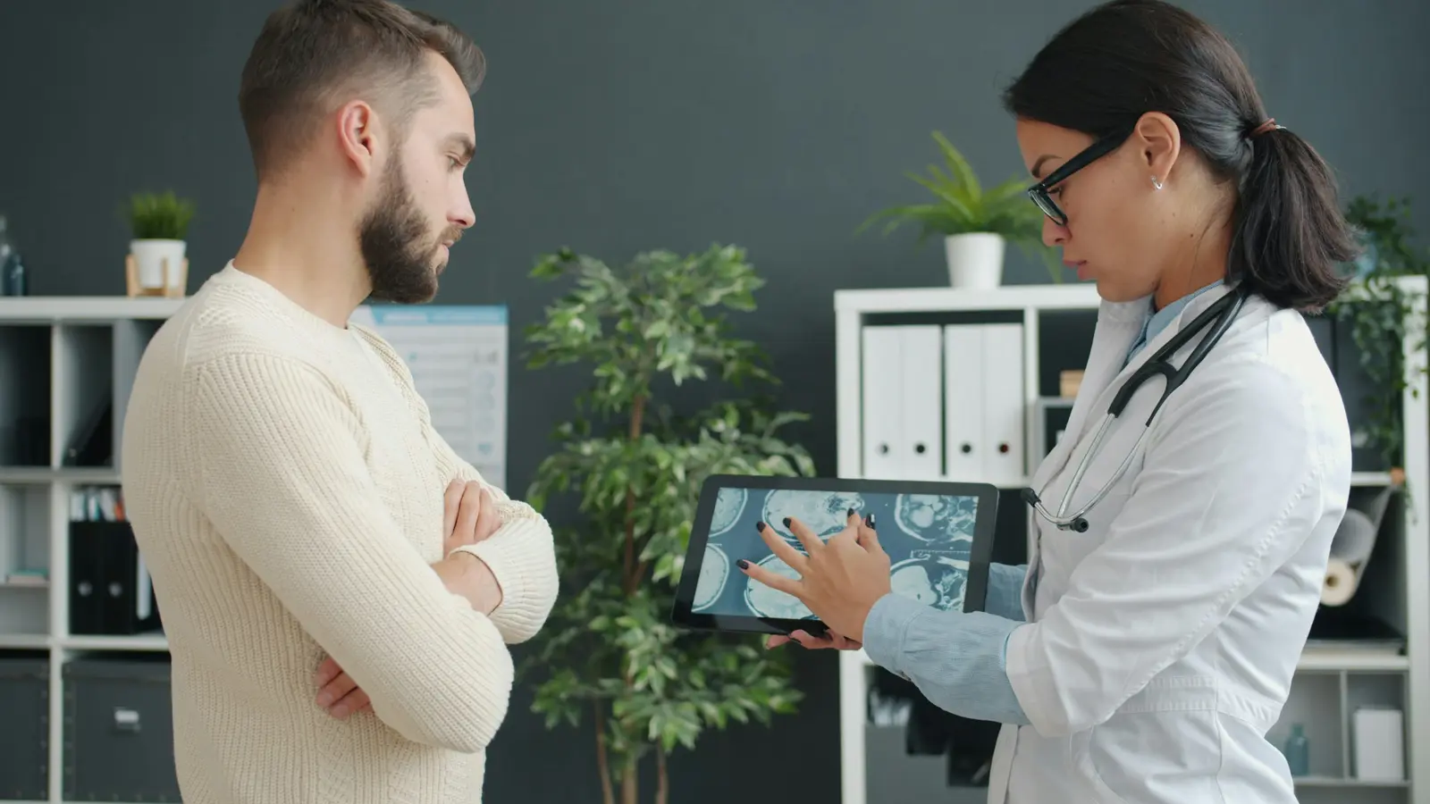 Profissional de saúde mostrando um exame em um tablet para o paciente